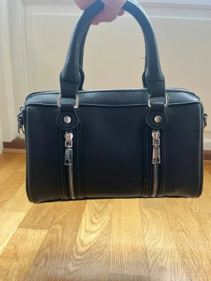 Zadig and Voltaire liknande väska från Misako. - Svart handväska i fejk skinn med två handtag och silverfärgade dragkedjor framtill. Väskan är från Misako🫰🏻💞