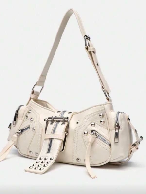 Vit axelremsväska med nitar och dragkedjor - Cool handväska i krämvitt konstläder med flera silverfärgade dragkedjor, nitar och spännen. Väskan har justerbar axelrem och detaljerade sömmar som ger en edgy look. Perfekt accessoar för att lyfta din outfit.