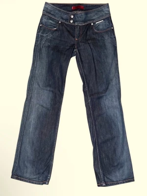 Lågmidjade straightleg jeans från Levi's - Snygga mörkblå straightleg jeans från Levi's med klassiska fem fickor och kontrastsömmar.🤗Jeansen har låg midja, dubbla knappar i gylfen och dekorativa sömmar på bakfickorna. De är i designen ”Billie May, heart pocket straight leg”. Bakfickorna är lite hjärtformade!!🥰🥰OBSSS!!! Storleken är 29x30 MENNN! Jag har vanligtvis 25/26 i midja inte 29 och jag är 162 cm och har strl 34 i vanliga jeans. Hör av dig om du vill ha mer bilder eller har frågor!❤️❤️