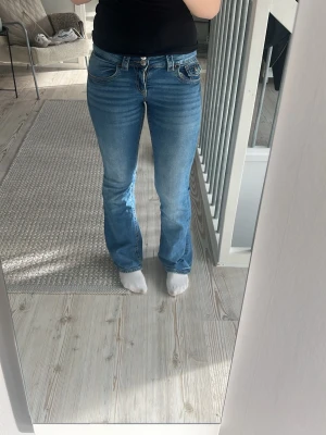 Blå bootcut jeans med stretch - Säljer ett par klassiska blå bootcut jeans med lätt utsvängda ben och normalhög midja. De kommer inte längre till användning därför säljer jag annars sitter de jättefint på mig. Jag är ungefär 160 cm lång och sitter perfekt i längden 💓