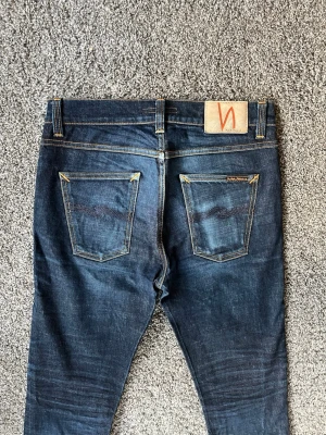 Lean Dean dry nudie jeans - As feta lean Dean jeans i dry modell, vilket syns på fadesen och innebär att de kommer fortsätta utveckla sjuka fades. Perfekt skick, inga defekter!