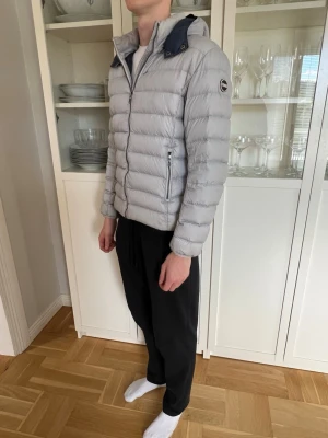 Grå Colmar Dunjacka - Jättefin vår/höst jacka från Colmar som också funkar på vintern. Mörkblå i huvan och grå i övrigt, väldigt fräsch färg. Bra skick, modellen på bilderna är 184 cm och 68 kg och den sitter lite kort på mig. Storlek 46, skulle säga small. Vid funderingar eller frågor är det bara att skriva! // Oskar😊