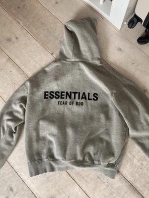 Essentials hoddie - Snygg essentials fog hoddie inga defekter bra kvalite passar om man är ca 165-175 är storlek S men har krymt till xs