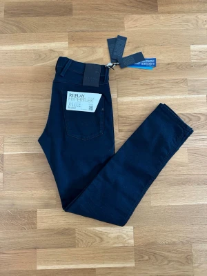Replay Hyperflex X-Lite jeans - Snygga mörkblå slim fit jeans från Replay, modell Anbass Hyperflex X-Lite. Jeansen har klassisk femficksdesign, stretchigt material och modern passform. Perfekta för dig som vill ha både stil och komfort i vardagen.