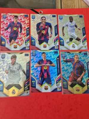 FIFA 365 samlarkort fotboll - Säljer ett set med sex FIFA 365 samlarkort från Panini. Motiven visar spelare från FC Barcelona och Real Madrid i sina klassiska matchställ. Korten har färgstarka bakgrunder med text och klubbmärken, samt detaljer i guld och blått.                                                         10kr styck, 20kr för legends