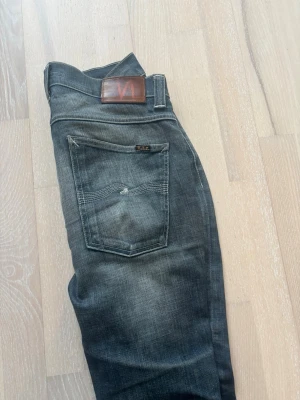 Nudie jeans med fet wash  - Säljer ett par klassiska blå jeans med tvättad effekt och slim fit passform. Perfekta till vardags för en avslappnad stil. Står storlek 34/32 men passar mindre jag som brukar ha 30/32 brukar ha på mig dem. Riktig fet wash och svåra att få tag på. Bara att skriva vid funderingar!