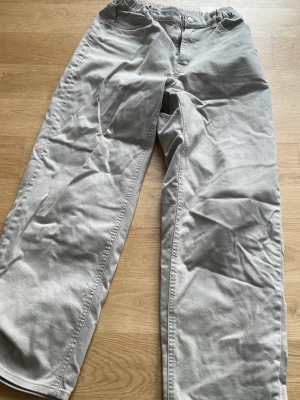 Ljusgrå raka jeans - Säljer ett par ljusgrå jeans med rak passform. Jeansen har klassisk femficksdesign och är tillverkade i ett mjukt denimtyg. 