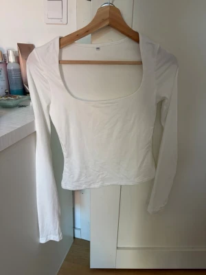 Långärmad topp med fyrkantig ringning - Två stilrena långärmade toppar i vitt och svart med snygg fyrkantig ringning. Perfekta att matcha med jeans eller kjol för en clean look. Tillverkade i mjukt bomullsmaterial som sitter skönt mot kroppen.