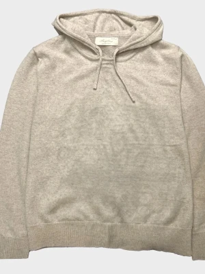 Sayless Kashmir  - Snygg beige hoodie från sayless med klassisk huva och dragsko. Tillverkad i Kashmir som känns skön mot huden. Perfekt för en avslappnad och stilren look. Ribbade muddar vid ärmslut och nederkant.Pris kan diskuteras. MVH stentorparchive⚓️