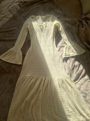 Vit långklänning med volangärm - Romantisk vit långklänning med v-ringning och utsvängda volangärmar. Jättefin lång strandklänning/cover up. Perfekt över bikini på stranden.