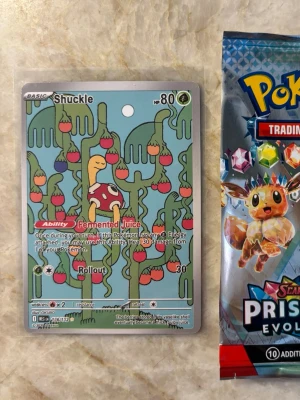 Illustration Rare Shuckle Pokemon - Här är mitt fina illustration rare av pokemonen Shuckle från prismatic evolutions. Jag jag skulle lägga en PSA rating skulle det vara mellan 7 och 8 