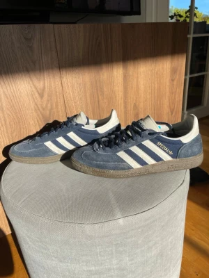 Adidas Spezial blå sneakers - Snygga Adidas Spezial sneakers i blå mocka med vita detaljer och klassiska tre ränder på sidorna. Skorna har en låg profil och gummisula med retrovibbar. Saknar orginalkartong.
