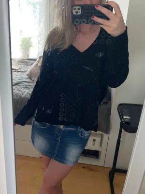 Svart stickad V-ringad tröja - En enkel och stilren svart stickad tröja med V-ringning och långa ärmar. Tröjan har ribbade muddar vid ärmslut och nederkant. Perfekt att matcha med jeans eller kjol🥰