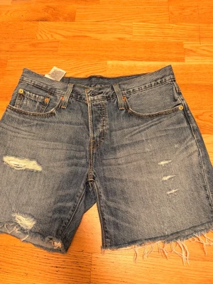 Levi's 501 jeansshorts med slitningar - Klassiska blå jeansshorts från Levi's. Är nästan helt oanvända och som nya. Även väldigt mjuka och sköna. Är öppen att diskutera priset💕