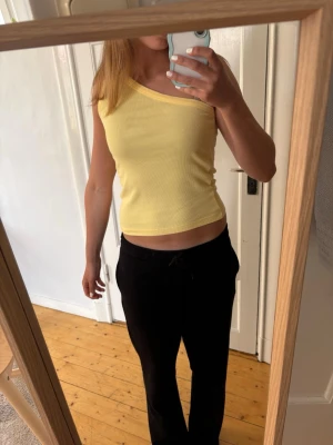 Ljusgul oneshoulder ribbad topp - Säljer en ljusgul ribbad topp med oneshoulder-design. Märker är Selected Femme och är köpt på Boozt’s hemsida!