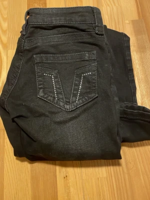 Svarta jeans med nitar på bakfickan - Snygga svarta jeans från Gina som är bootcut och väldigt lågmidjade. Dom är använd endast en gång eftersom dom är för korta mig. Jag är 170 och byxorna är i storlek 14+💓💓