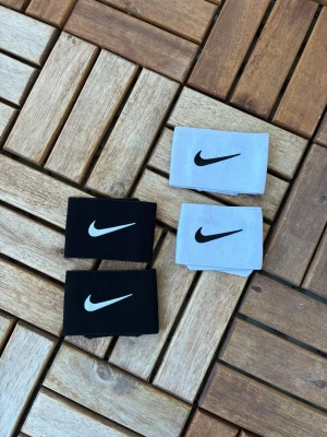 Nike benskyddshållare 2p - 2par benskyddshållare från Nike. De svarta är aldrig använda, vita är använda några gånger. Är inga specifika storlekar på dessa.
