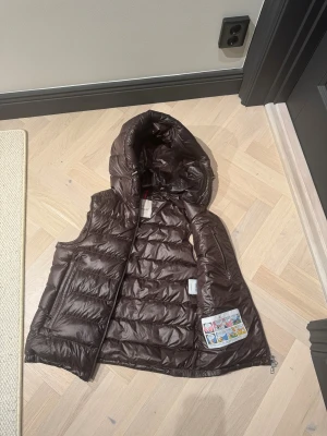 Moncler GUI Väst (Kvitto finns kvar!) - Kvitto finns kvar!!!! Säljer nu min moncler väst som är äkta de kommer finnas en kod på andra bilden av inlägget den koden kan ni skriva in på Moncler hemsida för bevis på att de är äkta vara  kan diskutera pris köpte den i Paris i Moncler butiken  original pris på den är 9550kr säljer den billigt vill bli av med den snabbt 