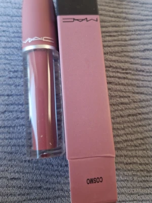 MAC Cosmo rosa läppstift - MAC Cosmo läppstift i en snygg rosa nyans med matt finish. Hylsan är elegant med genomskinlig botten och rosa lock. Perfekt för dig som vill ha en naturlig men ändå markerad look. Kommer i originalförpackning.