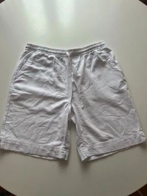 Soyaconcept Vita shorts med snörning - Snygga vita shorts med elastisk midja och snörning framtill.alridg använd. Tillverkade i ett lätt och luftigt material, perfekta för varma dagar. Två sidofickor ger en avslappnad vibe och enkel förvaring av småsaker.parfect till sommaren.