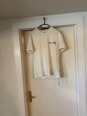 Vit Off-White t-shirt - Säljer en clean vit t-shirt från Off-White i mjuk bomull. Klassisk passform med korta ärmar och liten Off-White-logga tryckt på bröstet. Perfekt till jeans eller shorts för en enkel men snygg look.