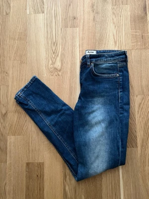 Blå Acne Jeans - Elegant Acne Studios jeans för män. Plagget är i nyskick utan några defekter, Storlek Waist 27 /Lenght 32. Hör av dig vid intresse/frågor. PRIS KAN DISKUTERAS!