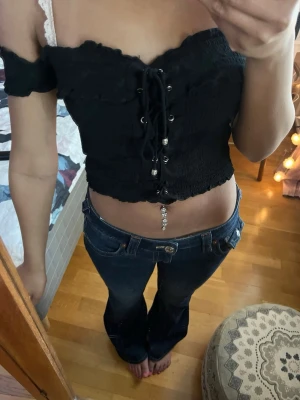 Svart croppad topp med snörning - Svart croppad topp med offshoulder och snörning framtill. 