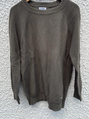 Olivgrön stickad tröja från SAMS - Snygg olivgrön stickad tröja från SAMS i storlek L. Tröjan har rund halsringning, långa ärmar och är ribbstickad för en stilren look. Perfekt för lager-på-lager och enkel att matcha med jeans eller chinos.