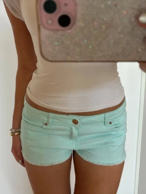 Turkosa lågmidjade shorts  - Såå fina turkosa lågmidjade vintage jeansshorts! midjemått rakt över: 39. Jag är 168 och det är mina bilder, köp via köp nu direkt eller Swish, kvar tills markerad som såld 💖 