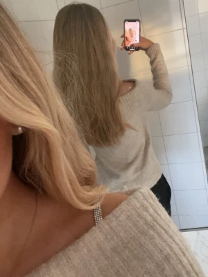 Beige off shoulder stickad tröja - Mysig beige stickad tröja med off shoulder-design och bred ribbad kant upptill. Långärmad och i mjukt material, perfekt för kyliga dagar.