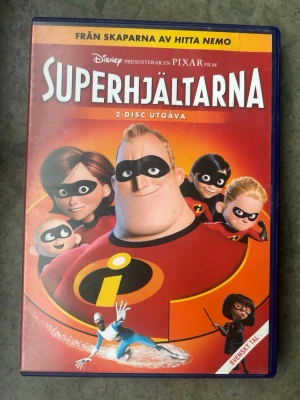 Superhjältarna 2 disc dvd - Superhjältarna - 2-Disc Utgåva. Från skaparna av Hitta Nemo presenterar Disney och Pixar filmen Superhjältarna. Denna utgåva innehåller två skivor. Textad på svenska, finska, engelska och isländska. Speltid 115 minuter. Åldersgräns 7 år.  Finns på språk: Svenska, Finska, Engelska, Isländska   OBS!! skivorna är begagnade så det kan förekomma repor/hairlines på skivorna, men då jag kollar igenom alla filmer jag säljer garanterar jag att alla funkar felfritt om inget annat står! :)