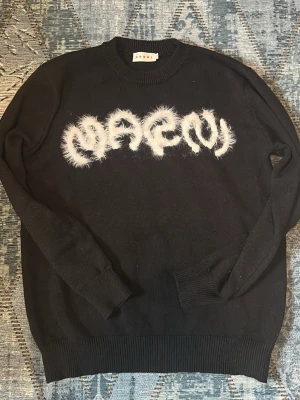 Svart stickad sweater - Säljer en svart stickad sweater från Marni. Skit fet tröja storleken passa även bra till både  om du bär S eller M. Funkar la även för tjejer.