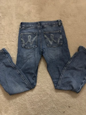 Lowwaist Bootcut jeans blåa med glittrigt mönster på fickorna - Blåa Bootcut lowwaist jeans med glittrigt mönster på fickorna ifrån Gina Tricot Young i slorleken 164/S. Fint och bra skick ,knappt använda. Skriv vid frågor 💕🤗🫰🏻❤️