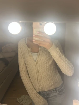 Beige kabelstickad kofta - Säljer en beige kabelstickad kofta med knappar framtill. Ifrån Cubus är i xs men passar mig i S den är helt slutsåld 