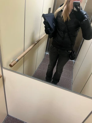 Svart pufferjacka med huva - Säljer en svart pufferjacka med huva och dragkedja framtill. Jackan har en klassisk modell. Perfekt för kalla vinterdagar och enkel att matcha med olika outfits.