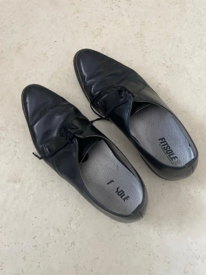 Svarta loafers från FitSole - Snygga svarta loafers från FitSole med klassisk spetsig tå och snörning. Skorna har en slät ovandel i blankt material och en låg sula. Perfekta för dig som gillar stilrena och tidlösa skor till vardagslooken. Stl 42 Herr skor #Vinted  #herrskor #skinnskor #läderskor #finskor #kostymskor #svartaskor #snörskor #oxfordskor #derbyskor #businessstyle #klassiskstil #vintagestyle #secondhand #preloved #budgetfynd #Fynd #😍😍