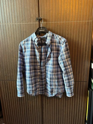 Blårutig skjorta från Polo Ralph Lauren - Säljer en klassisk blårutig skjorta från Polo Ralph Lauren. Skjortan har långa ärmar, knäppning framtill och en bröstficka. Tillverkad i mjuk bomull och har en avslappnad passform. Perfekt till jeans eller chinos för en chill look.