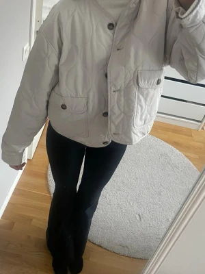 Ljus quiltad jacka med knappar - Säljer en ljus, quiltad jacka med croppad passform och stora fickor framtill. Jackan har knappar och en oversized look de är en L men jag har vanligtvis s och den passar ändå mig