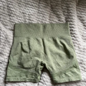 Gröna träningsshorts  - Snygga gröna träningsshorts med bred, ribbad hög midja och tight passform. Perfekta för gymmet eller andra träningspass. Materialet är stretchigt och mjukt. Shortsen har diskreta detaljer och en scrunch-effekt bak för extra form.💛