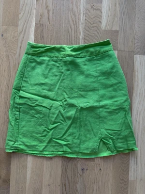 Minikjol från Gina Tricot  - Söt minikjol från Gina Tricot i strl 32 med fickor och liten slits. Oanvänd utan prislapp.
