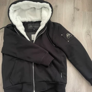 Svart hoodie från Moose Knuckles - Säljer en moose knuckles bunny, den är knappt använd. Jag fick den i present men den är för stor. Den är i 10/10 skick, tag medkommer. Skriv vid behov. Pris är inte hugget i sten 