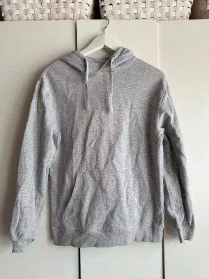 Gråmelerad hoodie. XS. Cubus. - Mjuk, gråmelerad hoodie med huva och dragsnören. Storlek XS. Från Cubus. Borstad insida. Klassisk känguruficka framtill och ribbade muddar vid ärmar och nederkant. Perfekt för en avslappnad look och enkel att matcha med andra plagg. Skrynklig på bilderna, men är i fint skick, inte mycket använd.