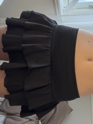 Svart volangkjol - Supersnygg svart kortkjol. Perfekt att styla med en croppad topp eller hoodie för en trendig outfit.