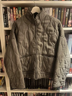 Quiltad jacka från Zara  - Säljer en superfin grå quiltad jacka från Zara med vågformat mönster och hög krage. Knappt använd. Perfekt nu till våren💕