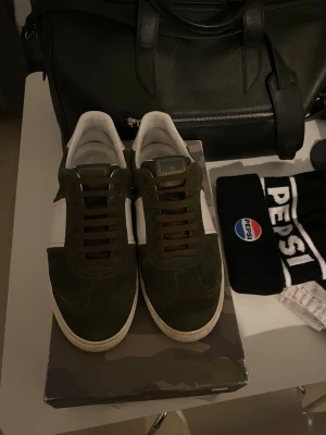 Olivgröna Valentino Flycruwe  - Tjena, säljer ett par sjukt snygga och stilrena Valentino flycruwe skor i färger olivgrön i 9/10 skick , finns inga defekter, ovanlig färg i så extremt bra skick. Dustbags och skosnören ingår. Hör gärna av er vid fler frågor eller funderingar, mvh