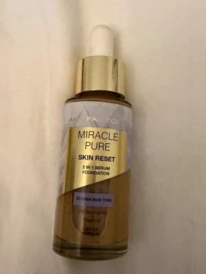 Miracle Pure Skin Reset Foundation - Miracle Pure Skin Reset 2 in 1 serum foundation från Max Factor i nyansen 80-85 Medium. Kommer i en glasflaska med pipett och guldfärgat lock. Ger jämn hudton och innehåller niacinamid och bakuchiol för extra hudvård.