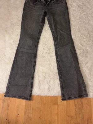 Grå bootcut jeans  - Säljer ett par grå bootcut lowwaist från gina, i strl 38. Inte jätteanvända då de är lite korta för mig som är 176 med långa ben. 