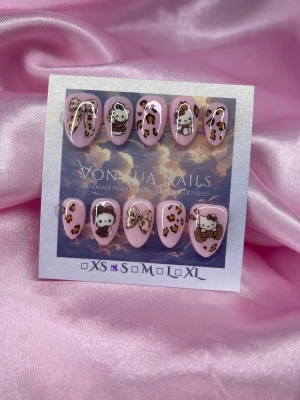 LeoKitty(S);Short Almond - Snygga handgjorda press-on naglar i rosa med leopardmönster och söta figurer samt rosett-detaljer. Naglarna har en kort almondform och är dekorerade med både djurmönster och gulliga motiv. Perfekt för dig som vill ha en unik och trendig nagelstil.S: 15 mm, 11,5 mm, 12 mm, 11 mm, 9 mm 