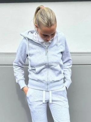 Russemerch Ljusgrå zip hoodie  Stl xs - Ljusgrå hoodie med dragkedja och stora fickor framtill. Modellen har huva med vita snören och ribbade muddar vid ärmslut och nederkant. Fint skick , det är några stygn små små som är i ena sidan. Se bild 7 inget som syns men ska veta om. Nypris 749;-