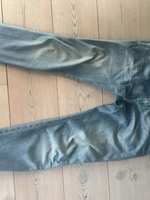 Ljusblå Replay Anbass Hyperflex - Säljer ett par ljusblå jeans med slim passform och klassisk femficksdesign. Jeansen har en snygg tvättad look och subtila slitningar för en avslappnad stil. Perfekta till en casual outfit och passar till det mesta i garderoben. Perfekt färg för våren